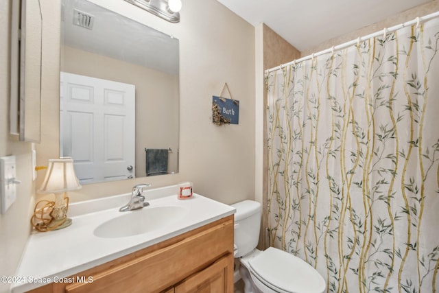 bathroom with vanity, toilet, and walk in shower