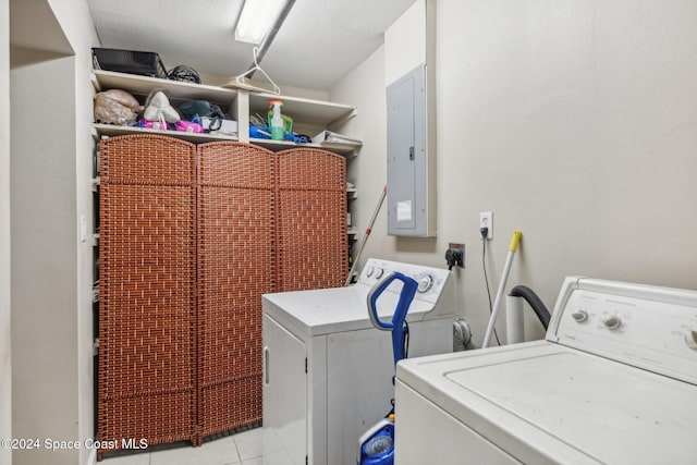 clothes washing area featuring light tile patterned floors, a textured ceiling, electric panel, and independent washer and dryer