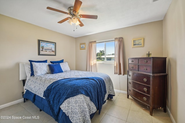 tiled bedroom featuring ceiling fan