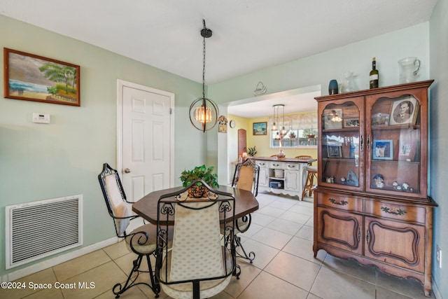 tiled dining room with a notable chandelier