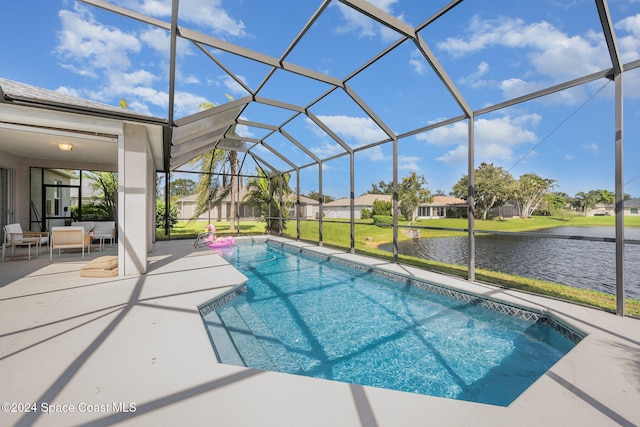 view of swimming pool featuring a yard, a water view, glass enclosure, and a patio area