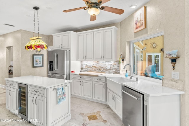 kitchen featuring kitchen peninsula, sink, white cabinets, beverage cooler, and appliances with stainless steel finishes