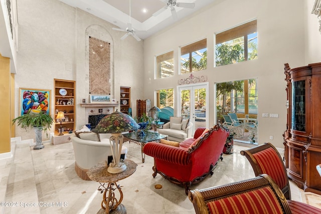 living room featuring a towering ceiling, french doors, a healthy amount of sunlight, and ceiling fan