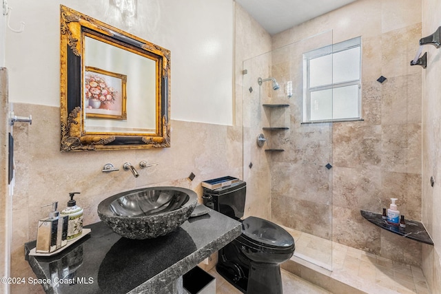 bathroom with toilet, sink, tile walls, and tiled shower