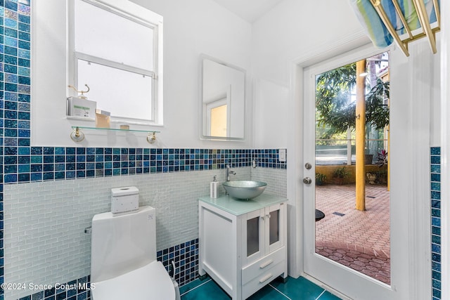 bathroom with vanity, tile walls, toilet, and tile patterned flooring