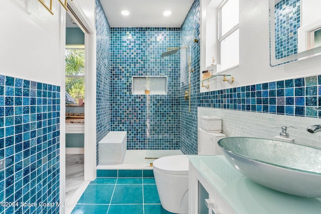 bathroom featuring tile walls, vanity, toilet, and tiled shower