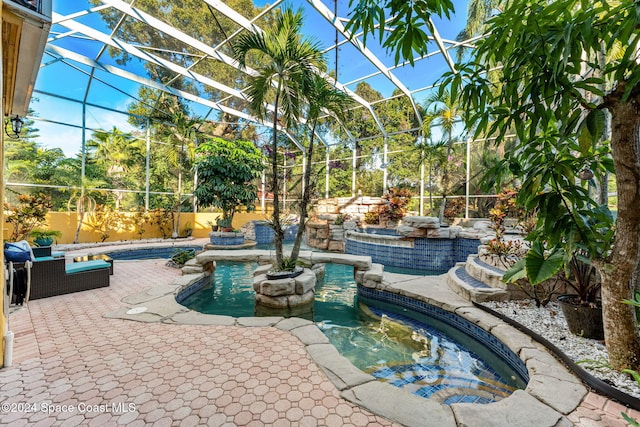 view of swimming pool featuring a hot tub, a patio, and glass enclosure