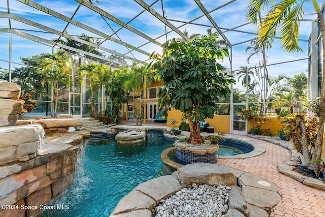 view of pool featuring an in ground hot tub, a patio area, a lanai, and pool water feature