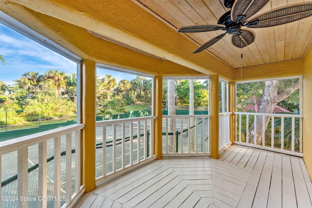 unfurnished sunroom featuring a water view, wooden ceiling, and ceiling fan