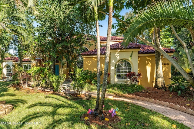 mediterranean / spanish home with a front lawn