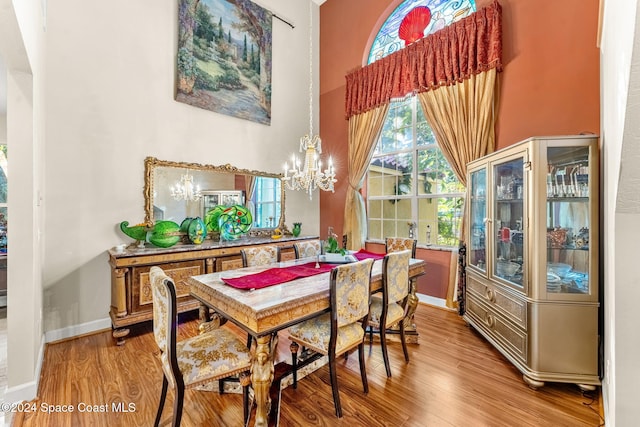 dining space with wood-type flooring and a chandelier