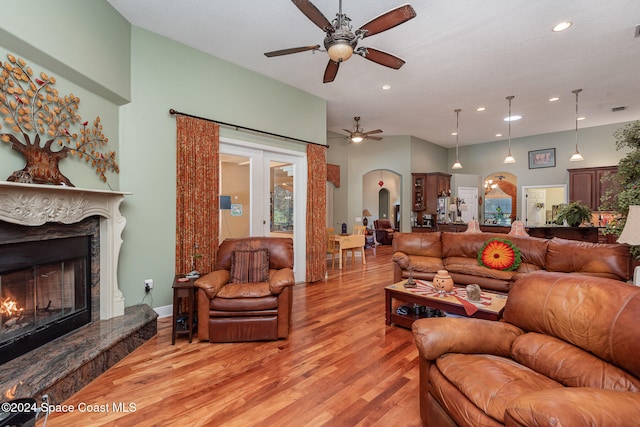 living room featuring light hardwood / wood-style floors, a premium fireplace, and ceiling fan