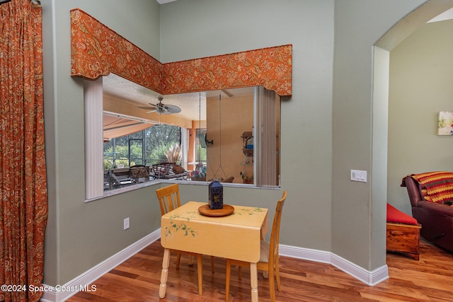 dining space featuring wood-type flooring and ceiling fan