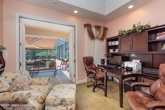 carpeted office featuring lofted ceiling and built in desk