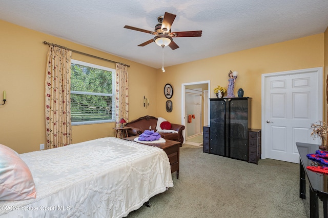 carpeted bedroom featuring a textured ceiling and ceiling fan