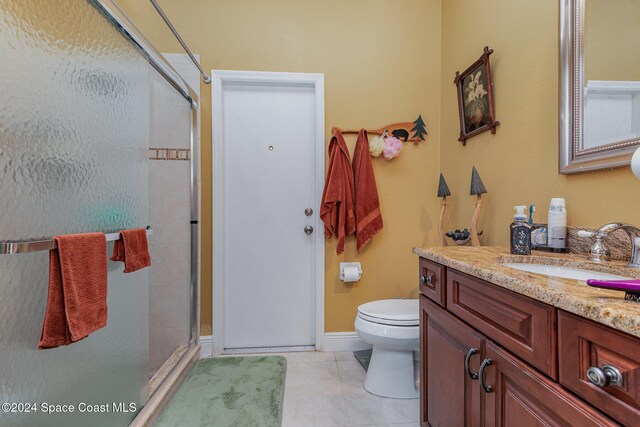 bathroom featuring a shower with door, toilet, tile patterned flooring, and vanity