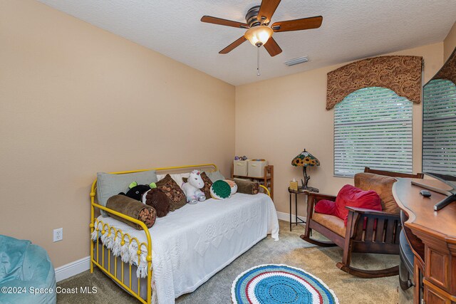 carpeted bedroom featuring a textured ceiling and ceiling fan