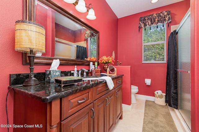 bathroom with tile patterned floors, toilet, a shower with curtain, vanity, and a textured ceiling