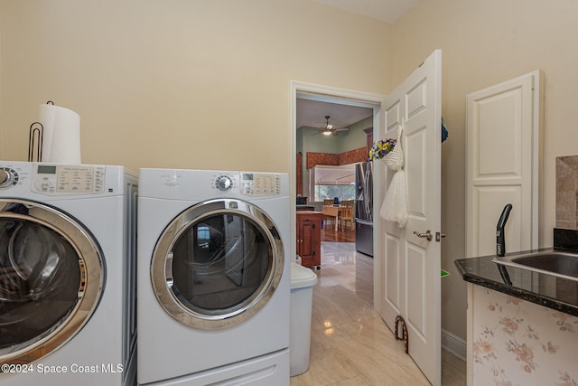 clothes washing area featuring sink, washing machine and clothes dryer, and ceiling fan