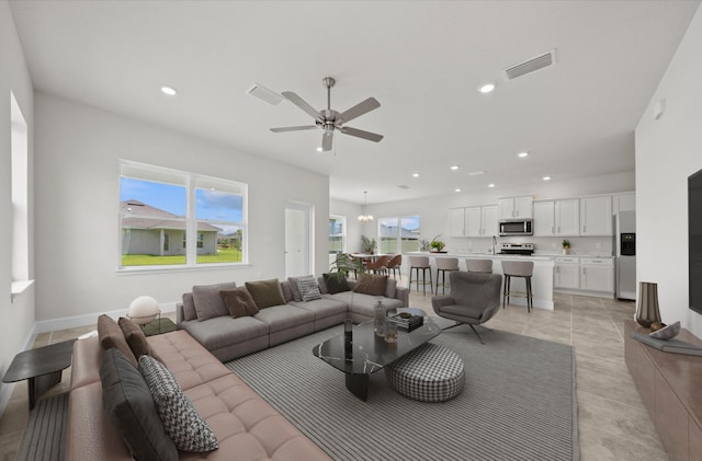 living room with ceiling fan, plenty of natural light, and light tile patterned floors