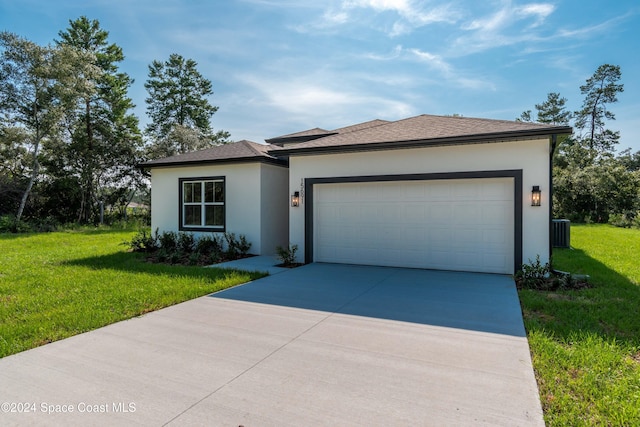 view of front of house with central air condition unit, a front yard, and a garage