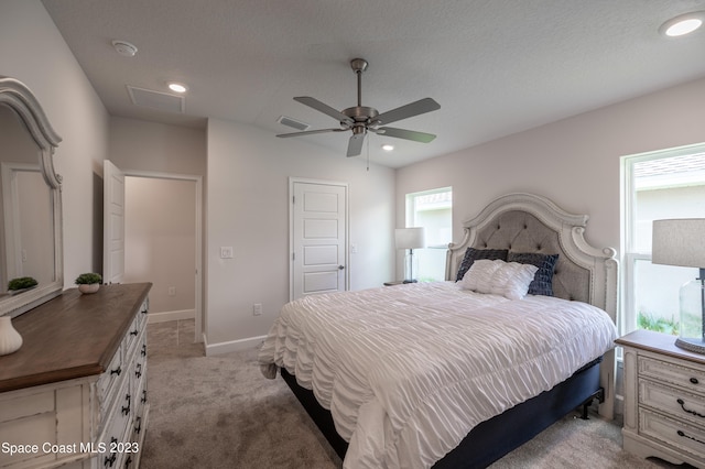 bedroom with light carpet, ceiling fan, and a textured ceiling