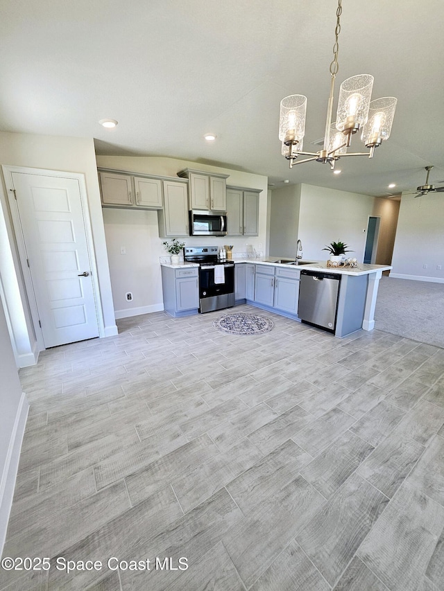 kitchen featuring pendant lighting, sink, gray cabinets, and appliances with stainless steel finishes