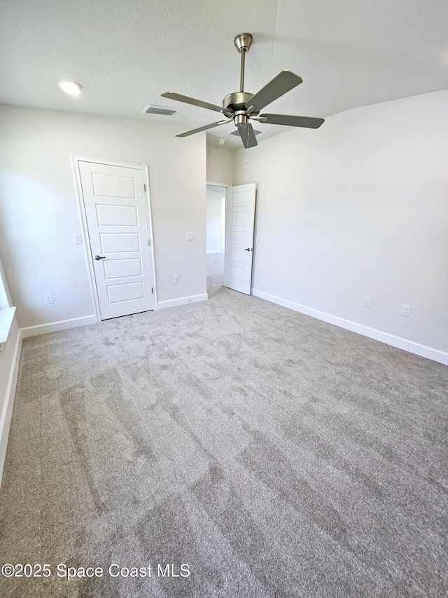 unfurnished bedroom featuring ceiling fan, carpet floors, and a textured ceiling