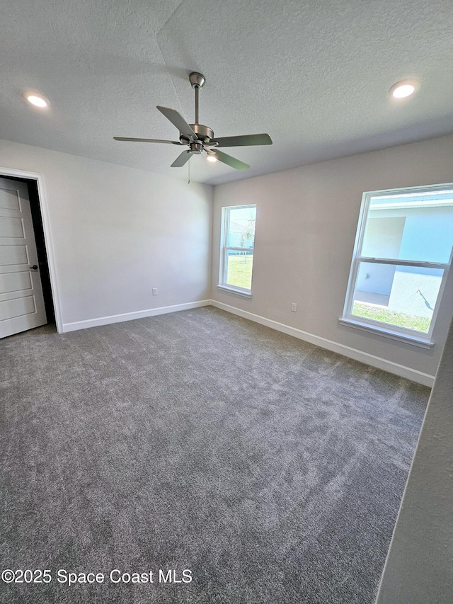 carpeted empty room with ceiling fan and a textured ceiling