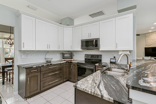 kitchen featuring sink, white cabinets, light tile patterned floors, appliances with stainless steel finishes, and light stone counters