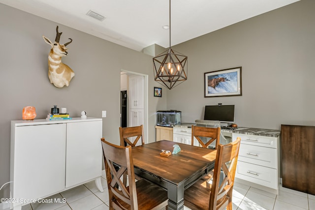 tiled dining room with an inviting chandelier