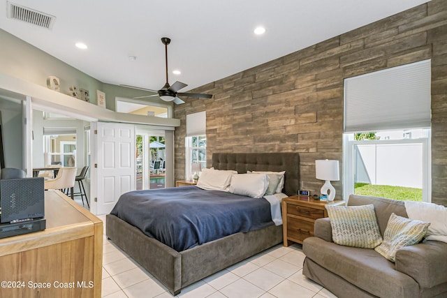 bedroom featuring multiple windows, ceiling fan, a fireplace, and light tile patterned floors