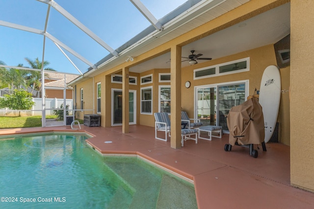 view of swimming pool with central air condition unit, ceiling fan, a lanai, and a patio area