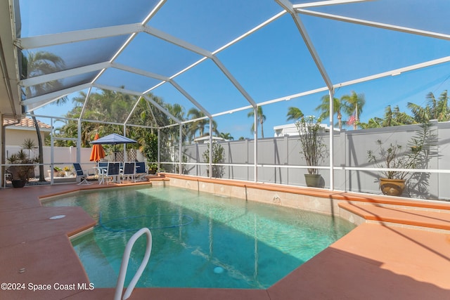 view of pool with a patio area and a lanai