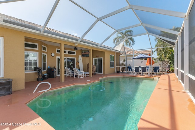 view of swimming pool with a patio area, a lanai, and ceiling fan