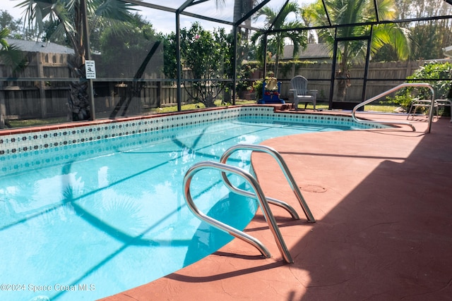 view of swimming pool with a patio area and glass enclosure