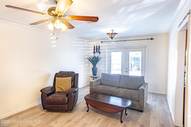 living room featuring crown molding, ceiling fan, a textured ceiling, french doors, and light wood-type flooring