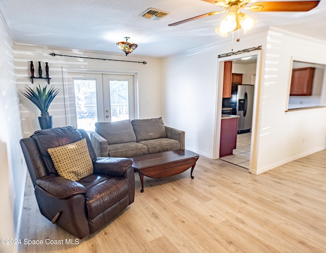 living room featuring crown molding, ceiling fan, light hardwood / wood-style floors, a textured ceiling, and french doors