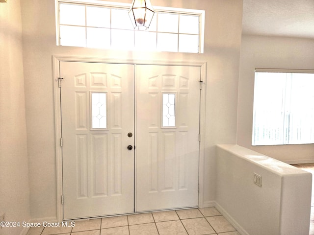 foyer entrance with light tile patterned floors and plenty of natural light