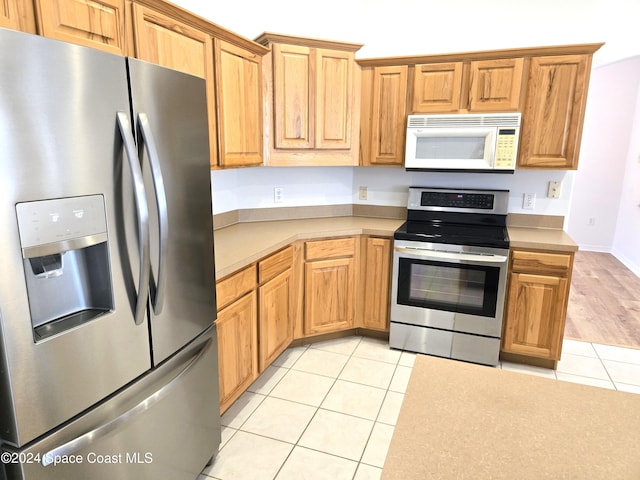 kitchen featuring stainless steel appliances and light tile patterned flooring