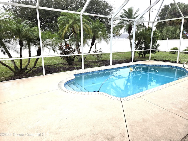 view of swimming pool with a patio and a lanai