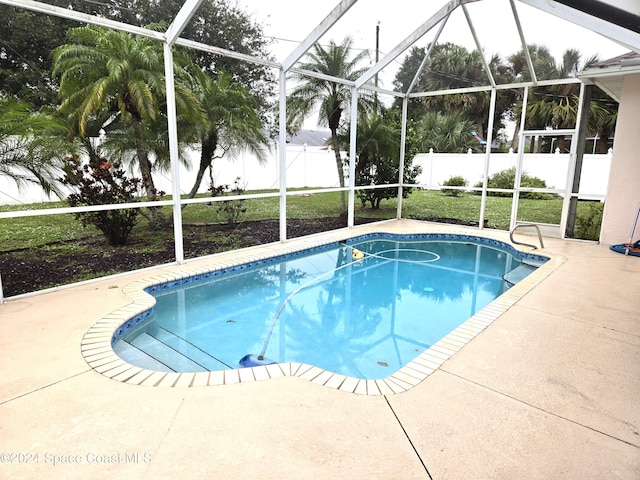 view of swimming pool with a patio area and a lanai