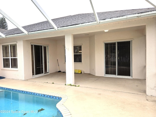 rear view of property with a patio and glass enclosure