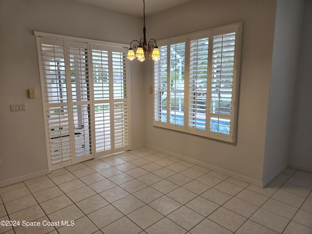 unfurnished dining area with a chandelier, a healthy amount of sunlight, and light tile patterned floors