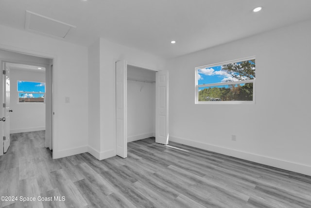 unfurnished bedroom with a closet and light wood-type flooring