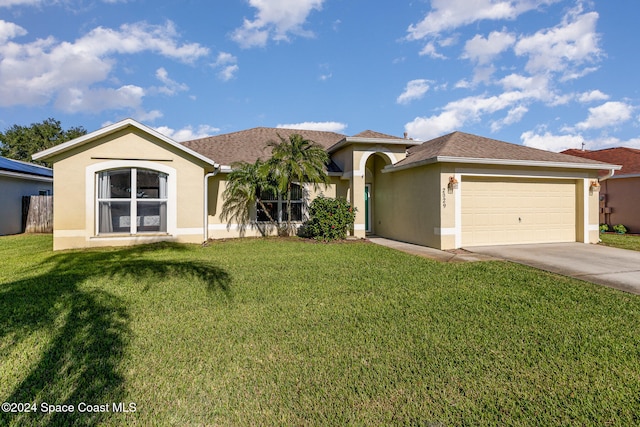 view of front of property featuring a front yard and a garage