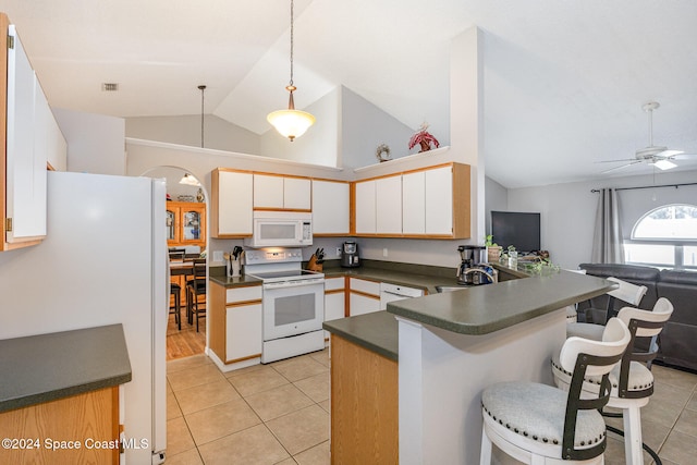 kitchen with kitchen peninsula, white cabinets, lofted ceiling, a breakfast bar, and white appliances