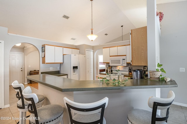 kitchen featuring lofted ceiling, kitchen peninsula, decorative light fixtures, and white appliances