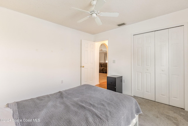 carpeted bedroom with a closet and ceiling fan