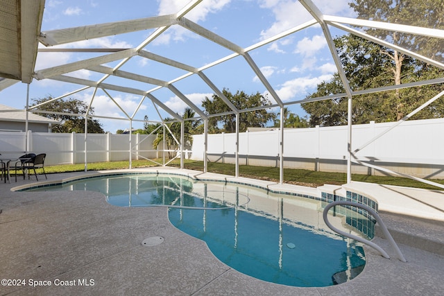 view of swimming pool with a patio area and a lanai